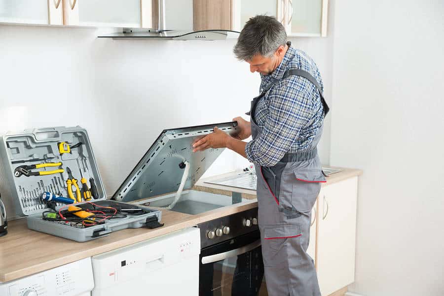 A technician repairing an electric cooktop Minneapolis & Surrounding Areas
